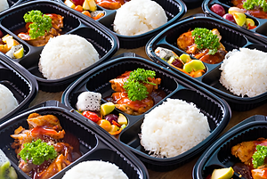 Professional catering display of a gourmet fusion bento box, showcasing a colorful balance of proteins, fresh vegetables, and